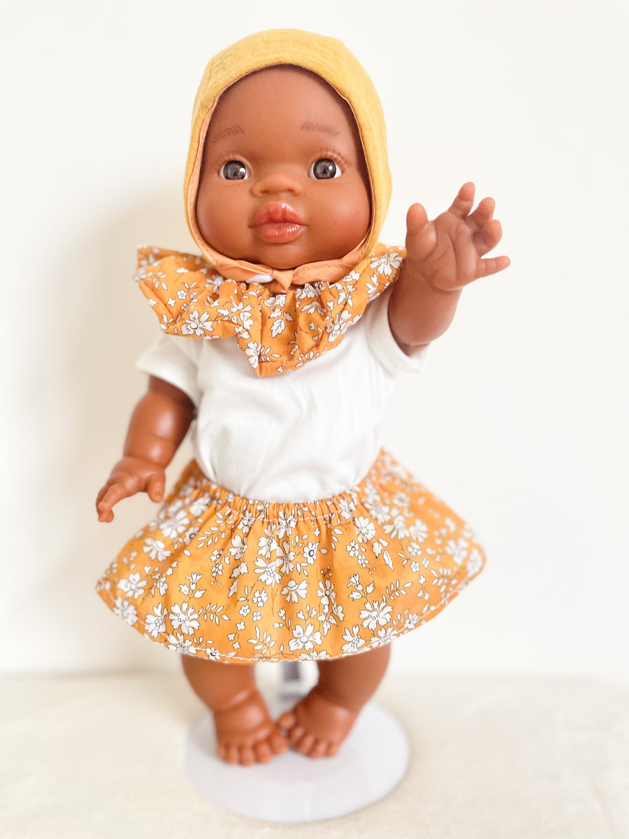 Poupon Gordi fille Paola Reina habillé par Les Juliettes Paris. L'ensemble comprend un poupon, une jupe, un tee shirt blanc et un col veritable chouchou en liberty ocre
